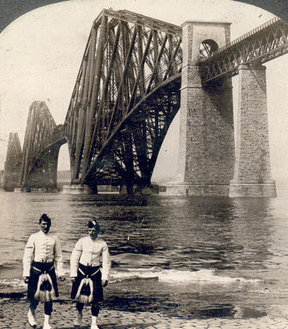 Highlanders in native costume at the great Forth Bridge, one and one-half miles long, spanning the Firth of Forth, Queensferry, Scotland