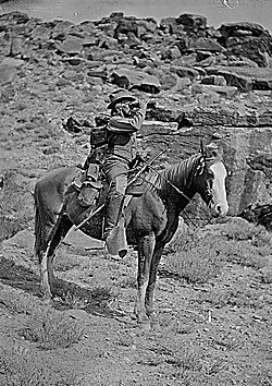 Prof. A.H. Thompson on his horse "Old Ute", looking through field glasses, about 1873. Old nos. 441, 468, 459, 661. See 663 also.