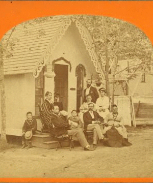 [Group posed in front of a cottage.] 1865?-1885?