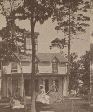 [Two women in front of small residential building.] 1870?-1890?